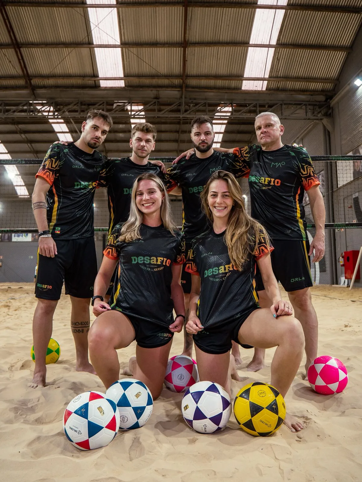 Time de futevôlei uniformizado na areia com uniforme personalizado da Eu Faço Camisetas